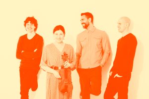 The Schmoozenbergs band lined up against white wall